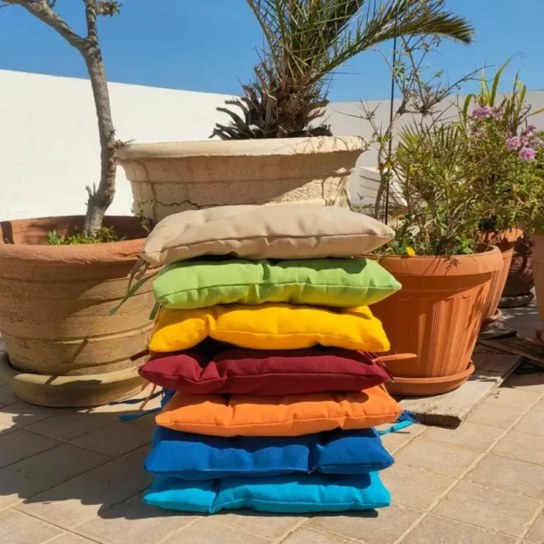 Galette de chaise extérieure 40x40 cm avec couleur vive sur un mobilier de jardin.