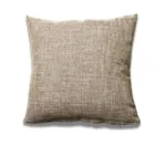 Housse de coussin Japa sur un fauteuil confortable.