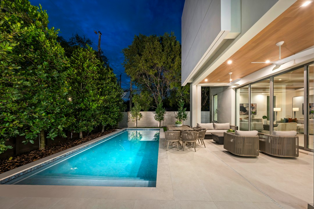 Maison moderne avec éclairage extérieur nocturne allée et patio